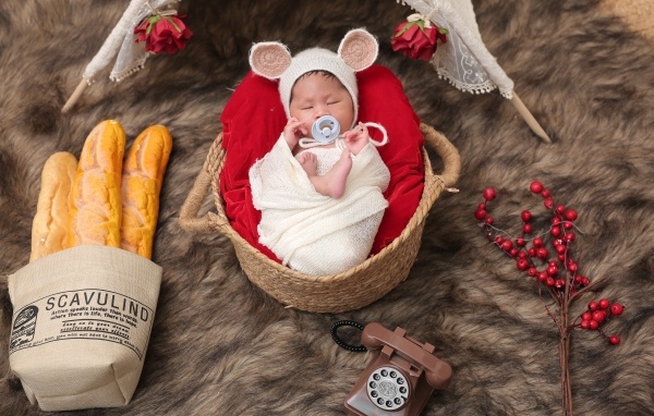 Ребенок спит в корзине с соской во рту