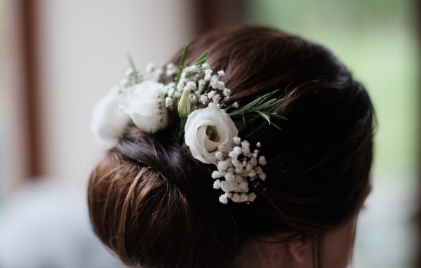 Белые цветы эустомы в свадебной прическе