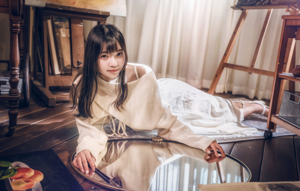 Девушка азиатка в белом платье лежит на полу