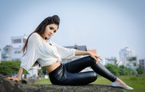 Девушка азиатка в черных кожаных брюках