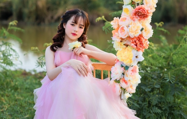 Красивая девушка азиатка в розовом платье с цветами
