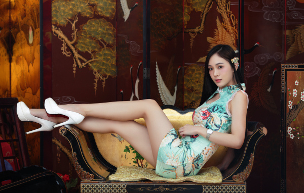 Красивая девушка азиатка лежит на диване