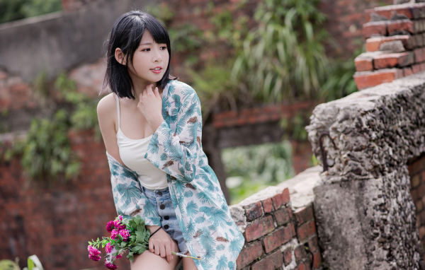 Красивая азиатка с цветком в руке