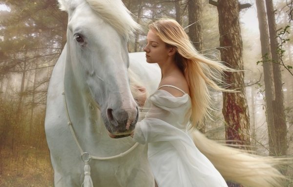 Красивая блондинка с конем в лесу