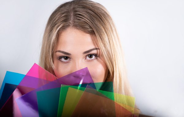 Красивая кареглазая девушка с разноцветной бумагой