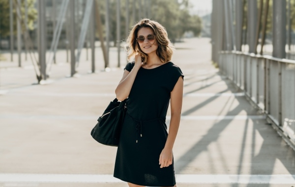 Красивая девушка в черном платье в очках