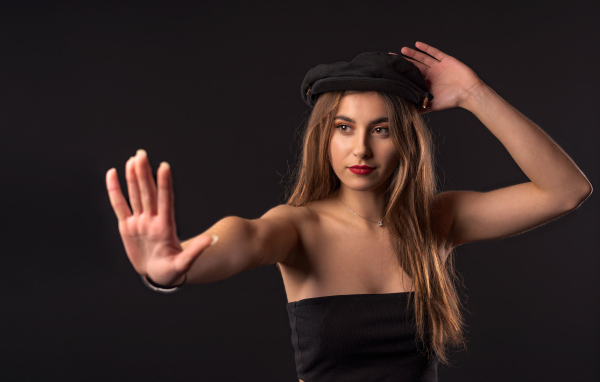 Красивая девушка в кепке на черном фоне