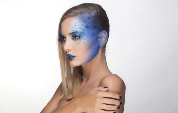 Красивая девушка с синим рисунком на лице