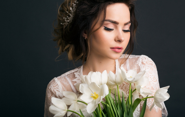 Красивая девушка с букетом белых тюльпанов на сером фоне