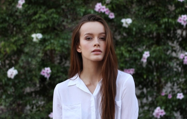 Красивая длинноволосая девушка в белой рубашке