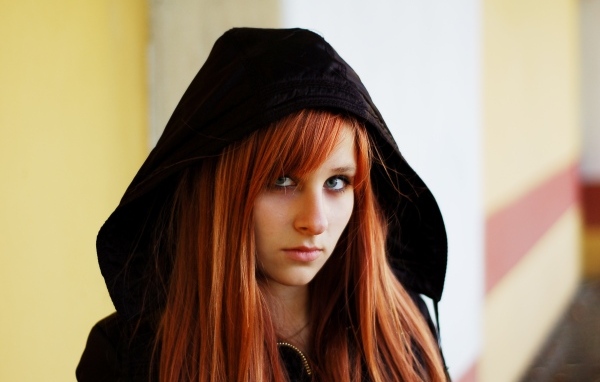 Красивая рыжеволосая девушка в черном балахоне