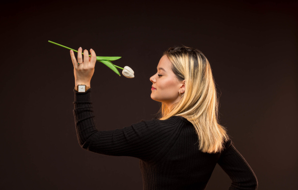 Блондинка с закрытыми глазами с тюльпаном в руках