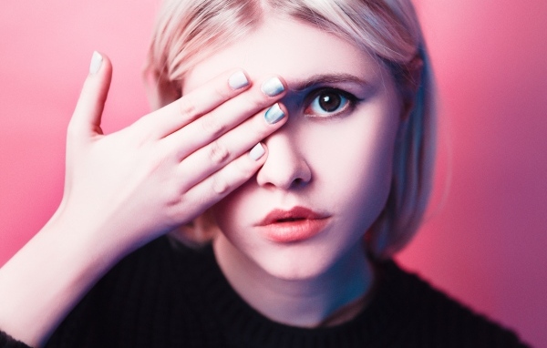 Кареглазая девушка закрыла глаз рукой