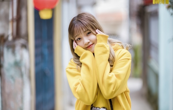 Милая девушка азиатка в желтом свитере