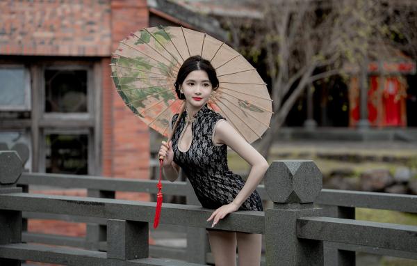 Симпатичная девушка азиатка с зонтом в руках