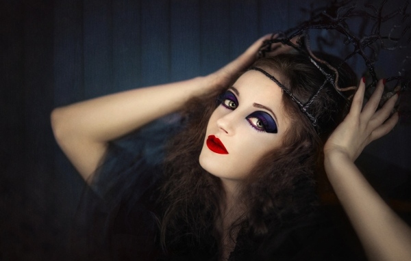 Девушка в черном наряде с ярким макияжем