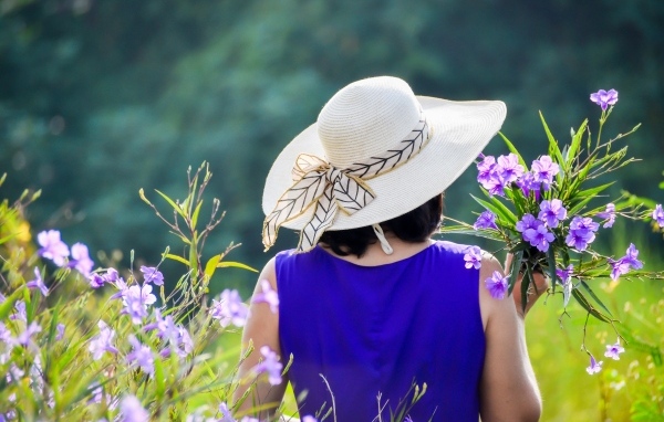 Девушка в шляпе с букетом полевых цветов