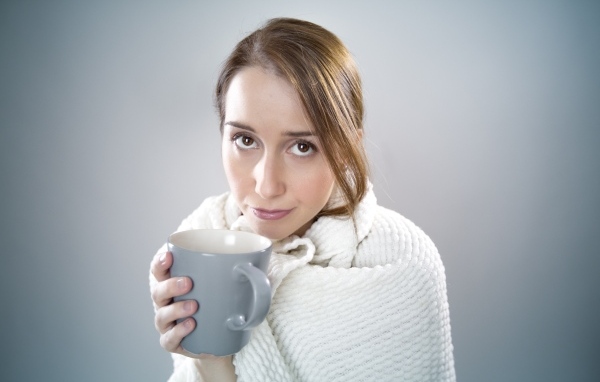 Девушка в белой кофте с кружкой в руке