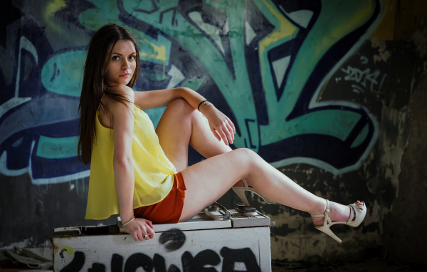 Девушка в заброшенном здании на фоне граффити