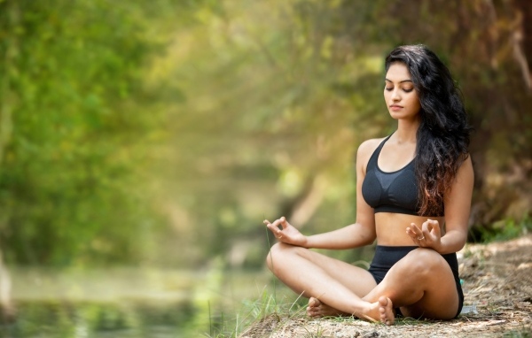 Девушка в черном костюме занимается йогой