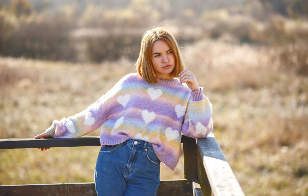 Девушка в свитере и синих джинсах
