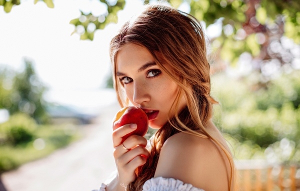 Девушка с красным яблоком в руке
