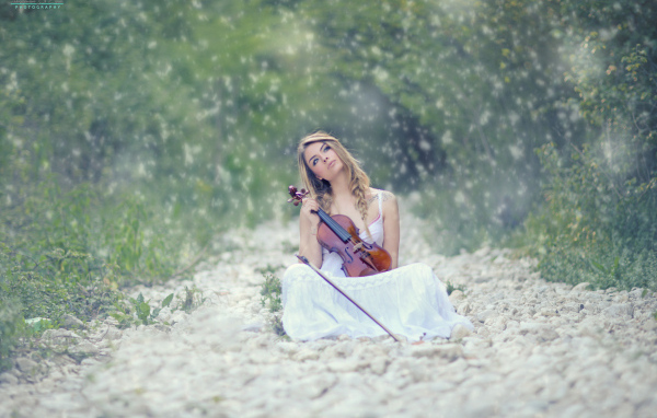 Девушка со скрипкой в руках в лесу