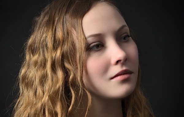 Длинноволосая кареглазая девушка на черном фоне