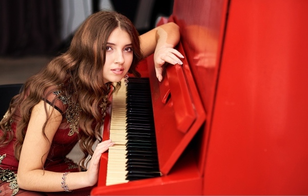 Девушка музыкант с красным пианино