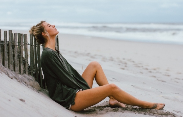 Романтическая девушка лежит на песке у моря