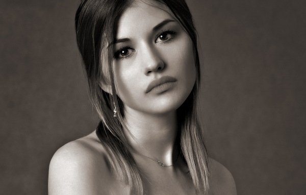 Грустное лицо красивой девушки на сером фоне