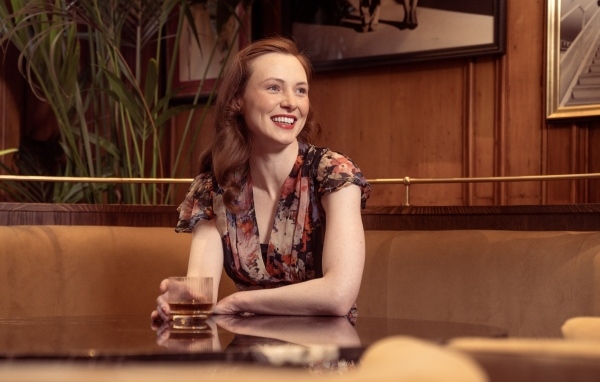 Улыбающаяся девушка за столиком в кафе