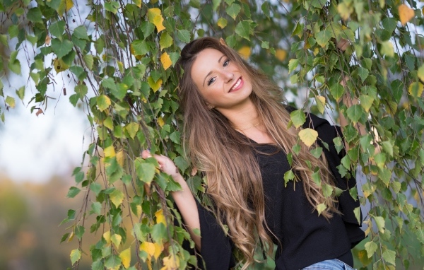 Улыбающаяся девушка в ветках березы