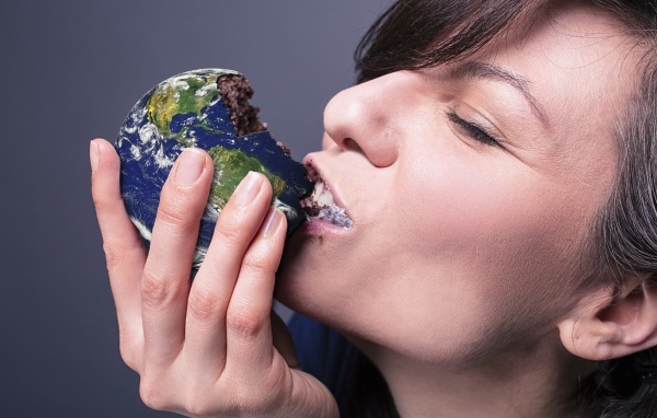 Девушка ест пирожное в виде планеты земля