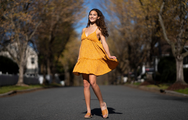 Молодая девушка в коротком платье на дороге  летом