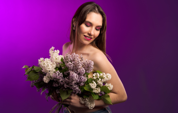 Молодая девушка с букетом ароматной сирени