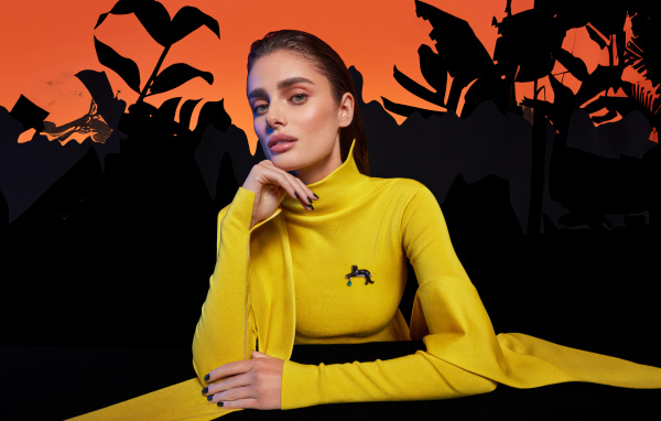 Красивая девушка модель Тейлор Хилл в желтом платье за столом