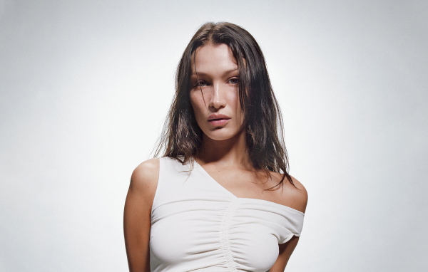 Модель Белла Хадид в белом платье на сером фоне