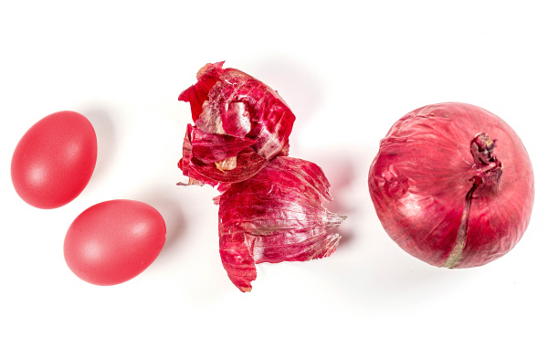 Окрашенные яйца с луком на белом фоне