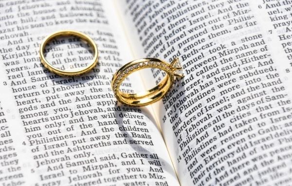 Два золотых обручальных кольца лежат на газете