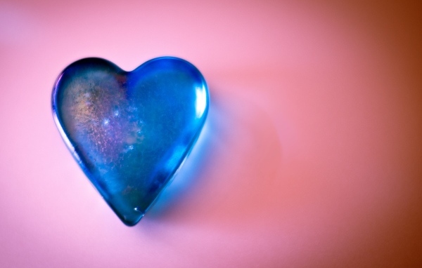 Синее стеклянное сердце на розовом столе