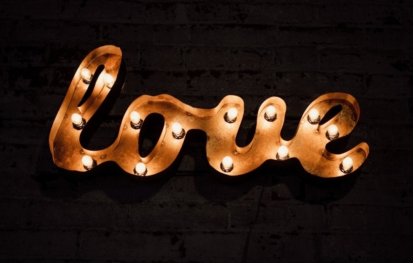 Светящаяся надпись любовь на черной стене