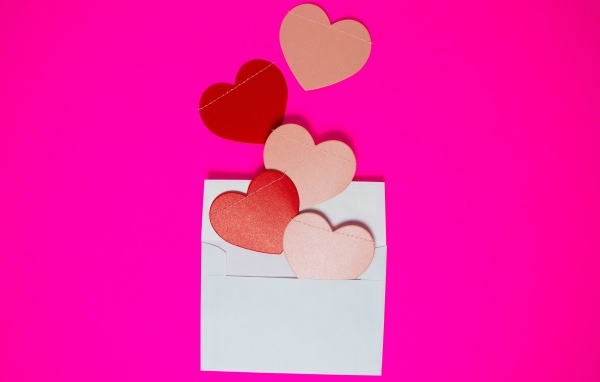 Сердечки с белым конвертом на розовом фоне
