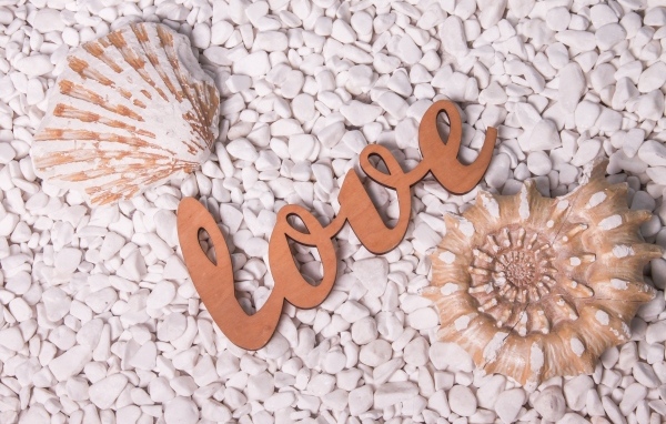 Ракушки и надпись любовь на белых камнях