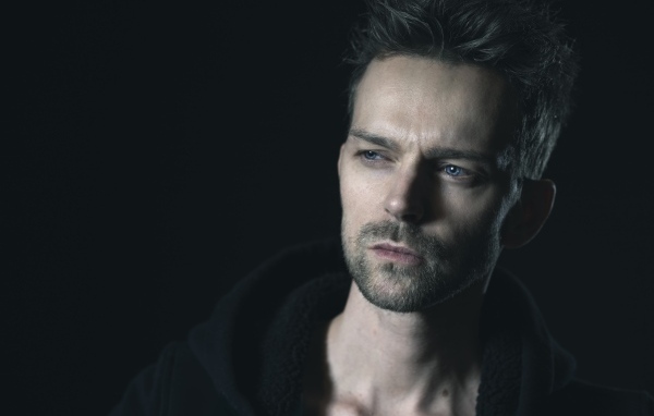 Серьезный голубоглазый мужчина на черном фоне