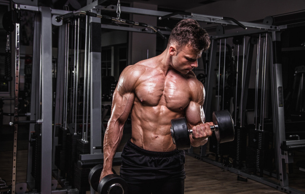 Сильный мужчина качает мускулы 