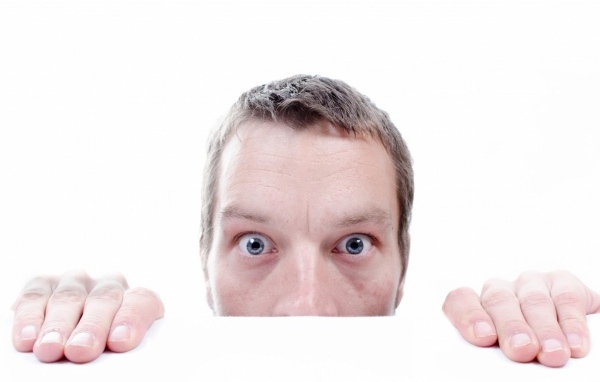 Удивленный взгляд мужчины на белом фоне