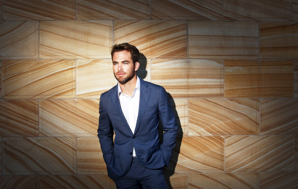 Американский актер Крис Пайн в костюме у стены