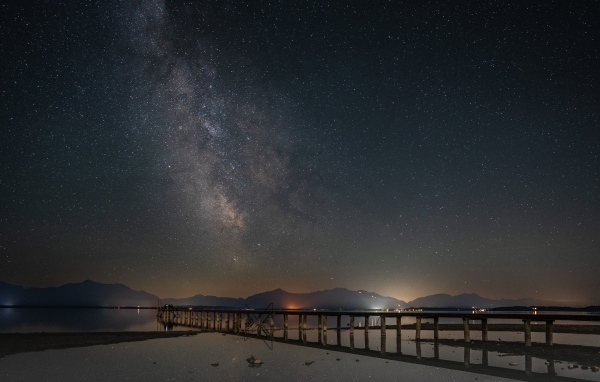 Млечный путь в небе над ночным фьордом