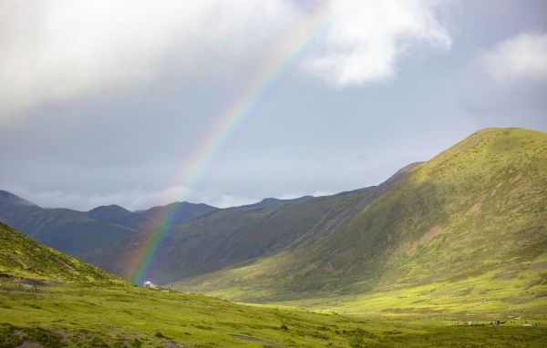 Радуга над покрытыми зеленью холмами